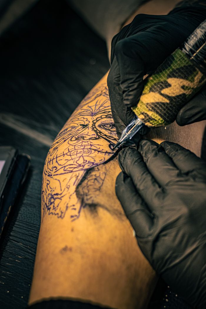 gallery-3 Artistic tattoo design process on arm in a tattoo studio, showcasing intricate craftsmanship and tattoo culture.
