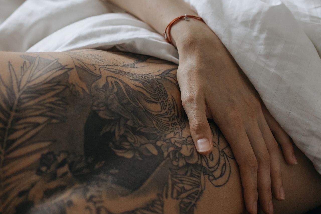 services-03 Close-up of a hand resting on tattooed skin, depicting intimacy and connection.